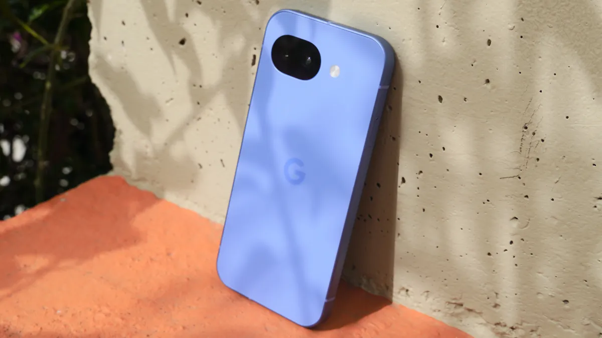 Blauwe Google Pixel 11 tegen een betonnen wand in de zon