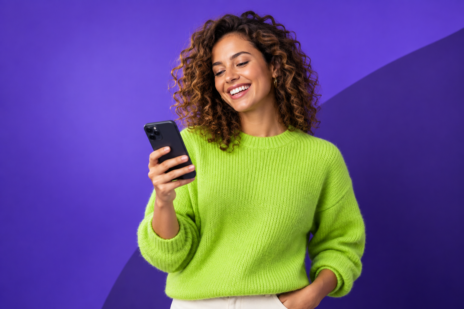 Vrouw bekijkt haar telefoon tegen een paarse achtergrond